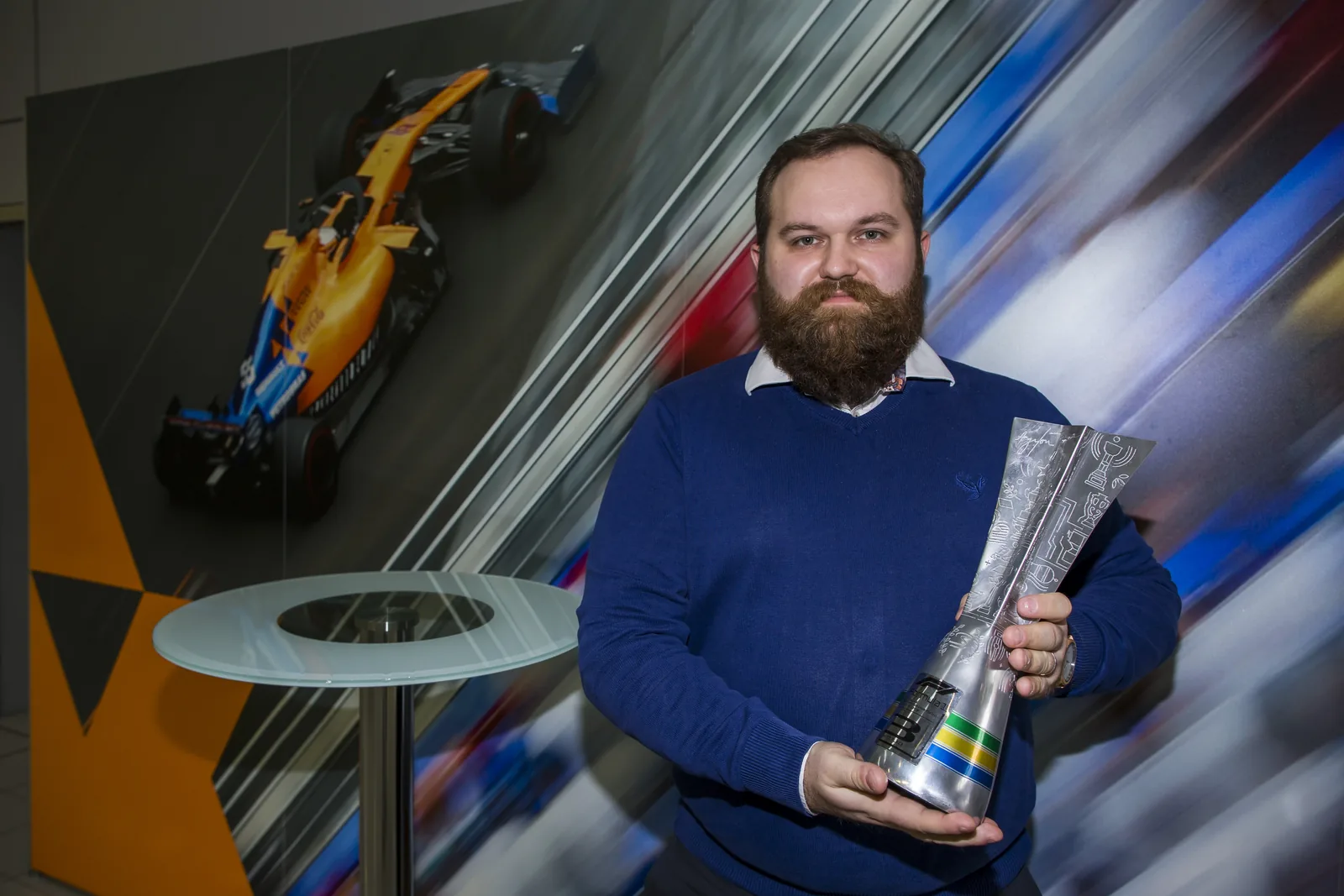 Patryk Sokołowski at McLaren with a Formula 1 trophy